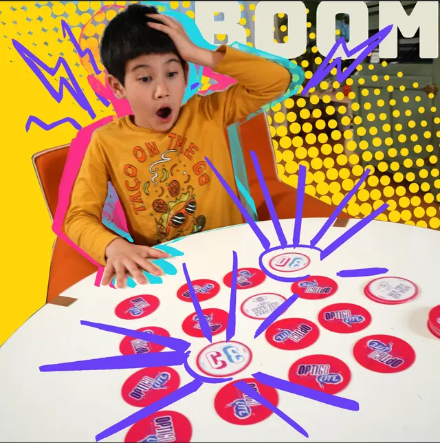 A kid mid-BOOM over a table of OPTIGO Lite discs